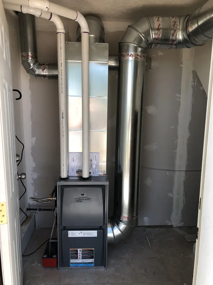 New high-efficiency furnace with PVC venting installed in a utility closet