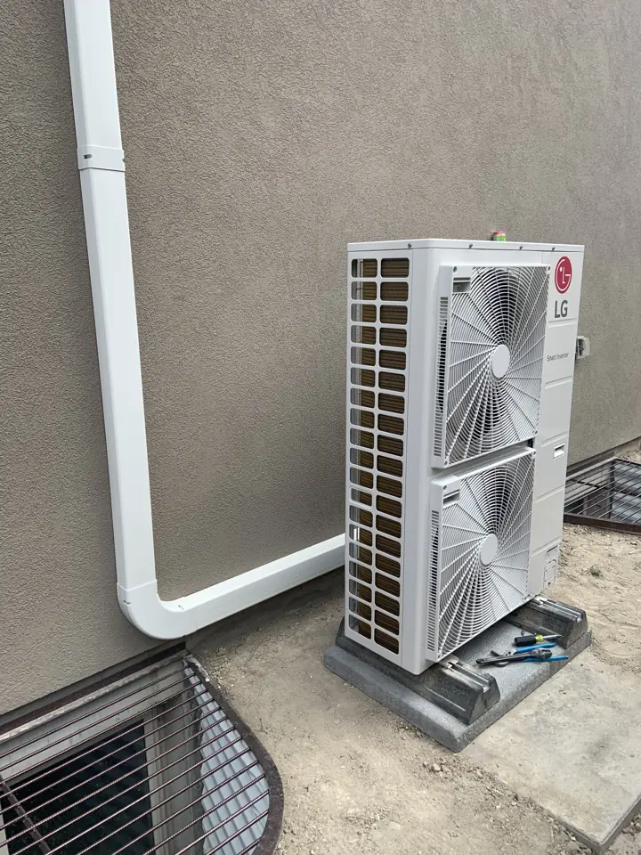 Newly installed LG heat pump outdoor unit on a wall bracket, a job by I Know A Guy HVAC in the Salt Lake Valley